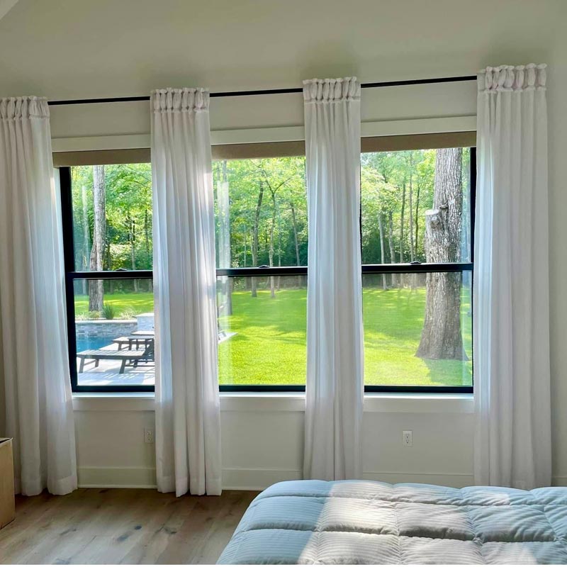 bedroom with drapery panels covering windows
